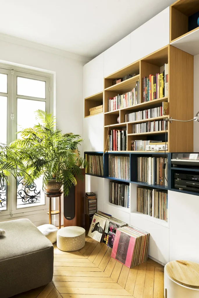 Salon d'un appartement rénové, rangement, collection de vinyles et plantes vertes